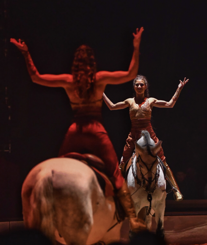 Deux cavalières se font face, souriantes et levant les bras avec grâce.