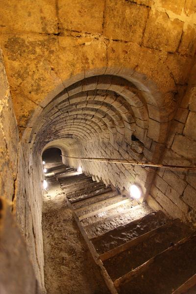Un escalier dans un tunnel en pierre qui descend dans les sous sols de Pontoise